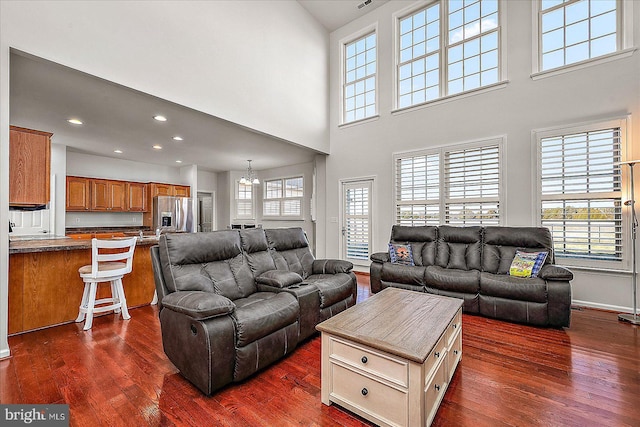 living area featuring a chandelier, baseboards, dark wood finished floors, and recessed lighting