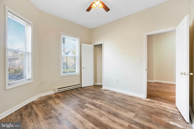 interior space with a baseboard radiator, wood finished floors, a ceiling fan, and baseboards