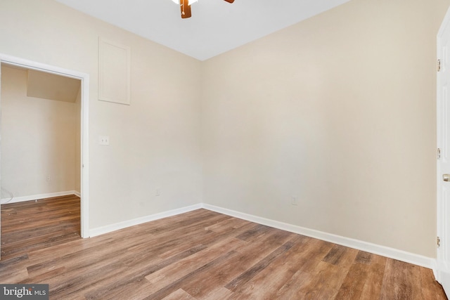 spare room with a ceiling fan, baseboards, and wood finished floors