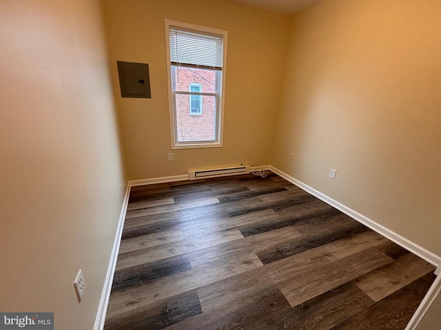 spare room featuring baseboards, electric panel, a baseboard heating unit, and dark wood finished floors