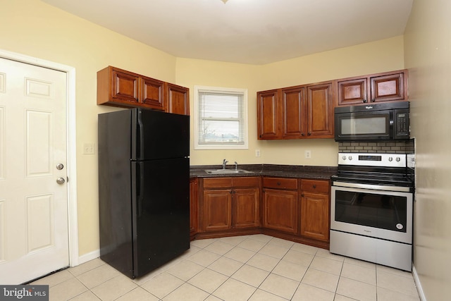 kitchen with light tile patterned floors, black appliances, dark countertops, and a sink