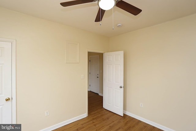 spare room with ceiling fan, baseboards, and wood finished floors