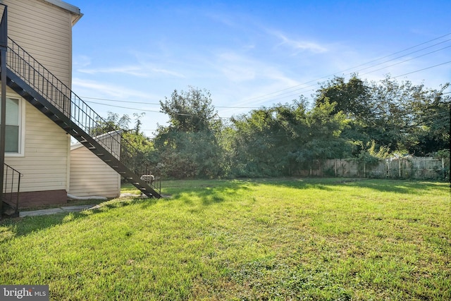 view of yard featuring stairs and fence