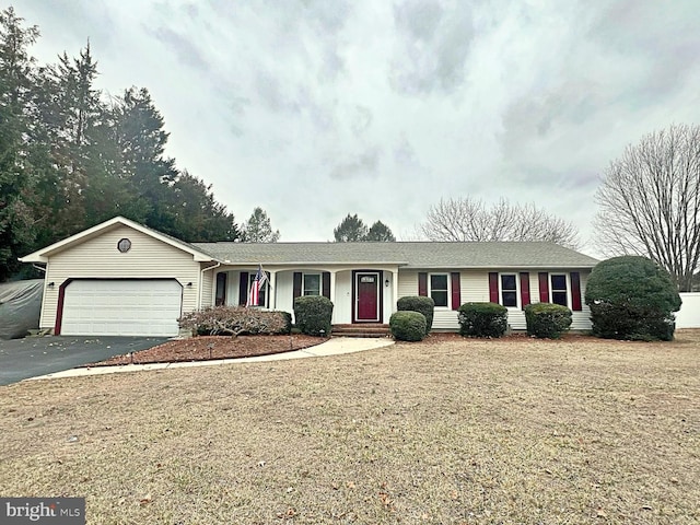 ranch-style home with a garage and aphalt driveway