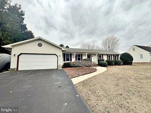 single story home with an attached garage and aphalt driveway