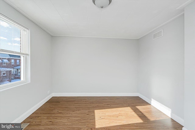 unfurnished room with visible vents, baseboards, and wood finished floors