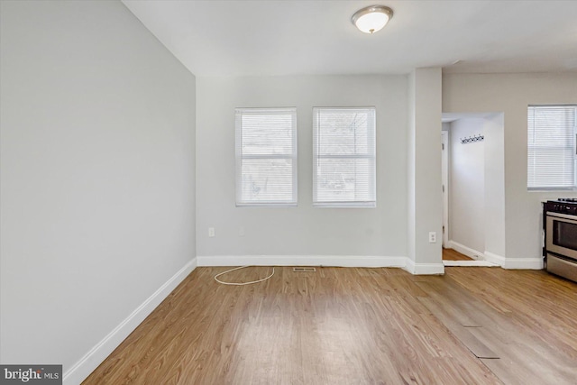 unfurnished living room featuring baseboards and wood finished floors