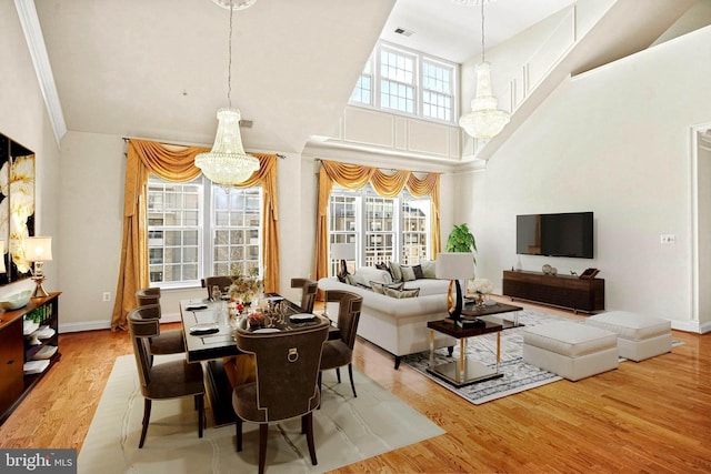 dining area with wood finished floors, a wealth of natural light, and a notable chandelier