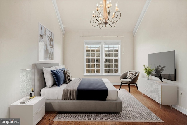 bedroom with a chandelier, crown molding, baseboards, and wood finished floors