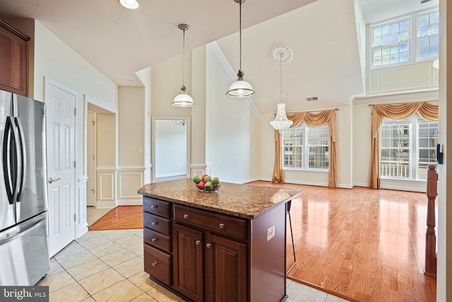 kitchen with visible vents, pendant lighting, a decorative wall, and freestanding refrigerator