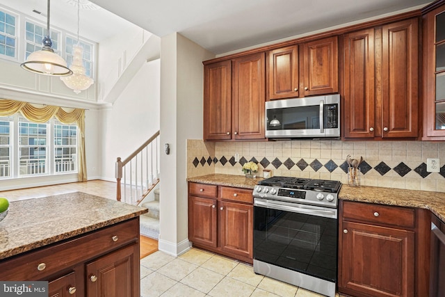 kitchen with stainless steel appliances, light tile patterned floors, glass insert cabinets, and tasteful backsplash