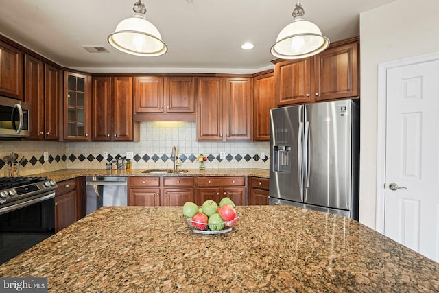 kitchen with stainless steel appliances, visible vents, backsplash, glass insert cabinets, and a sink