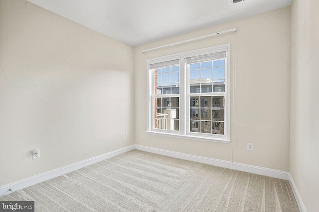 carpeted spare room with baseboards