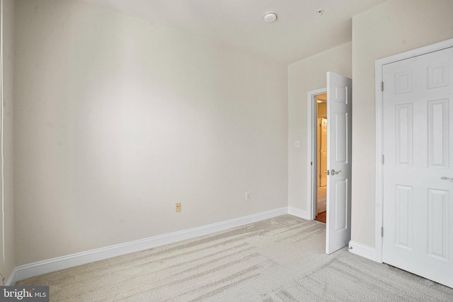 unfurnished bedroom with light carpet and baseboards