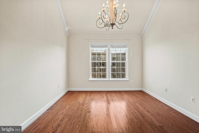 unfurnished dining area featuring a notable chandelier, baseboards, ornamental molding, and wood finished floors