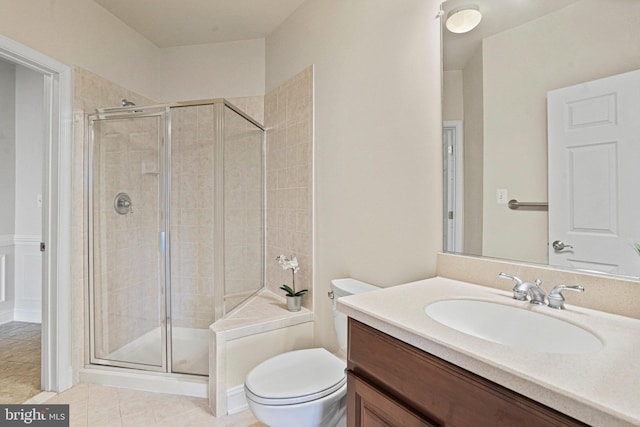 bathroom featuring a stall shower, tile patterned flooring, vanity, and toilet