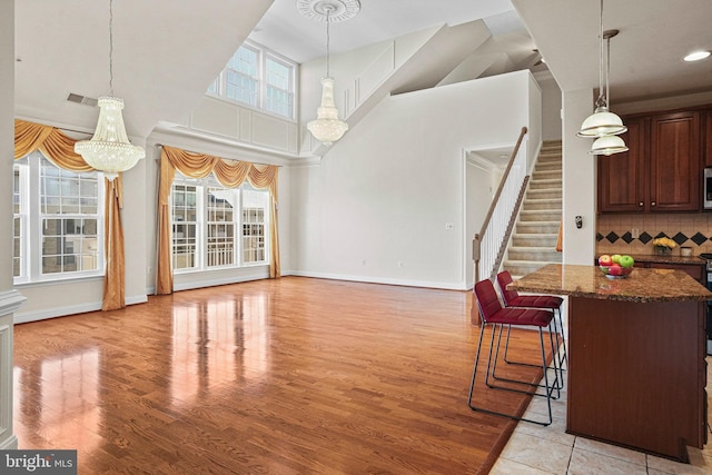 kitchen featuring plenty of natural light, tasteful backsplash, dark stone counters, and light wood-style floors