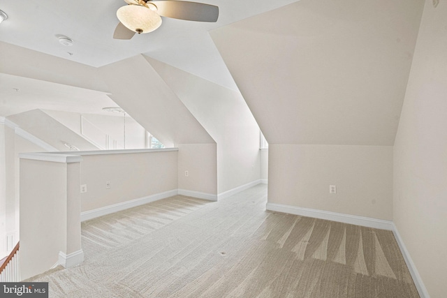 additional living space featuring carpet floors, baseboards, a ceiling fan, and lofted ceiling