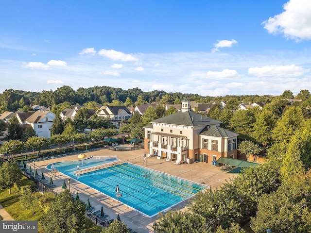 community pool with fence and a patio