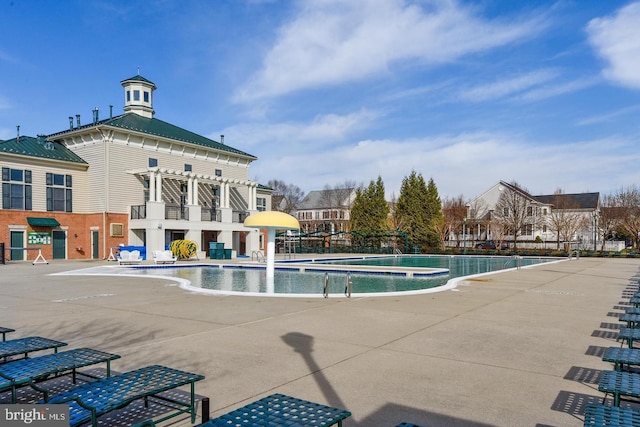 pool with a patio area and fence