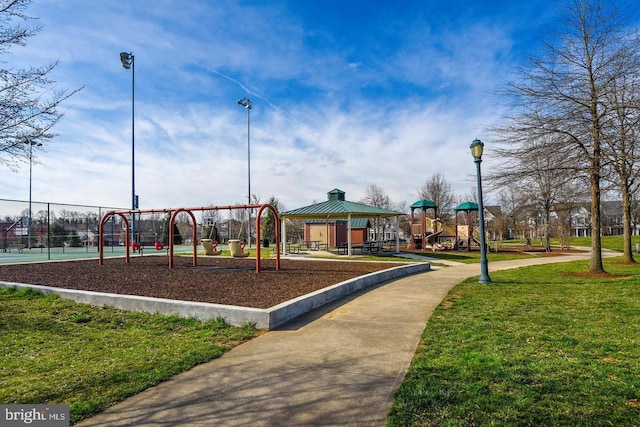 community jungle gym featuring a lawn and fence