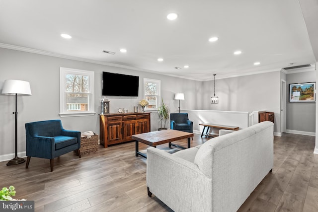 living room featuring baseboards, ornamental molding, wood finished floors, and recessed lighting