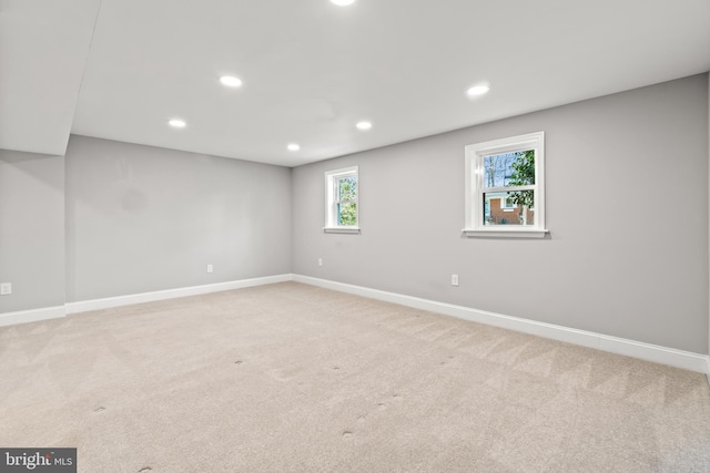 basement with baseboards, recessed lighting, and light colored carpet