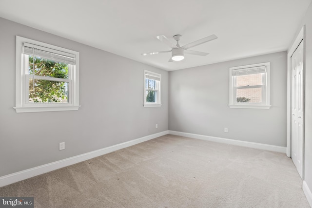 unfurnished bedroom featuring baseboards, a closet, a ceiling fan, and light colored carpet