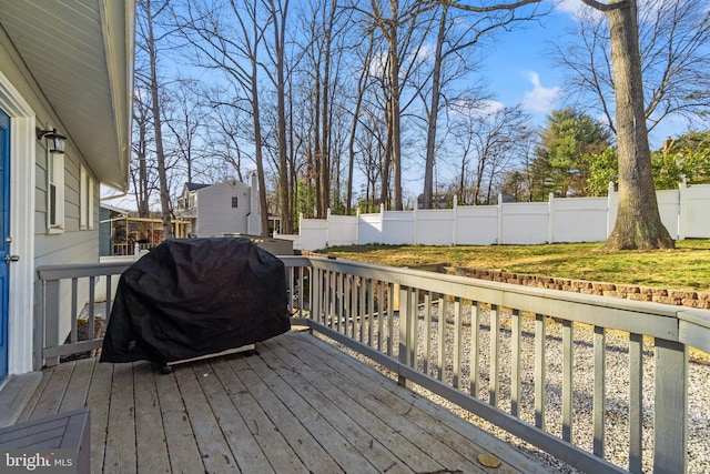 wooden terrace featuring a fenced backyard and area for grilling