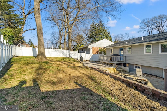 view of yard featuring an outdoor fire pit, a fenced backyard, a deck, and a patio