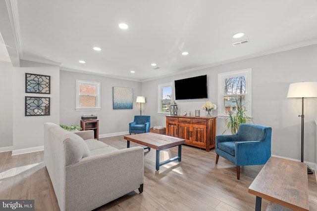 living room with light wood finished floors, visible vents, and a wealth of natural light