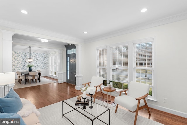 living room with recessed lighting, wood finished floors, wainscoting, decorative columns, and crown molding