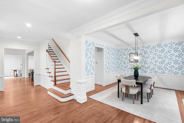 dining area with ornamental molding, stairway, light wood-style flooring, and wallpapered walls