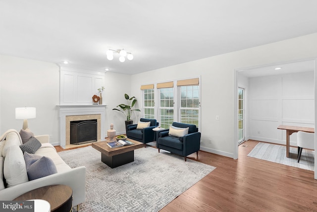 living room with light wood-type flooring, a fireplace, and baseboards