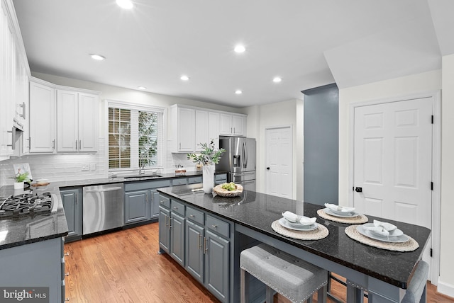 kitchen with stainless steel appliances, white cabinetry, light wood-style flooring, and gray cabinetry