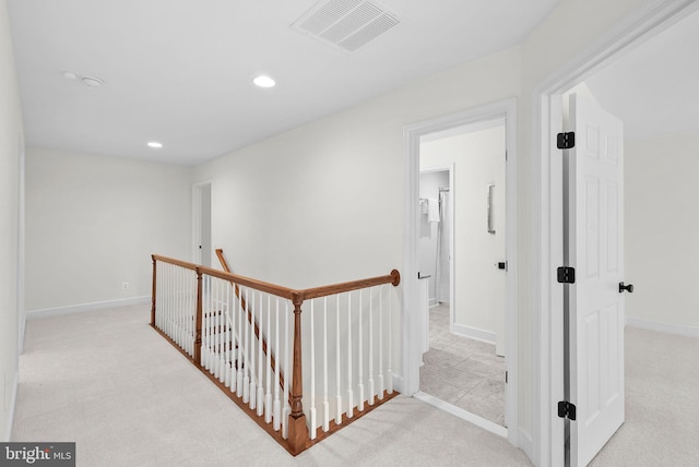 corridor with carpet flooring, an upstairs landing, visible vents, and recessed lighting