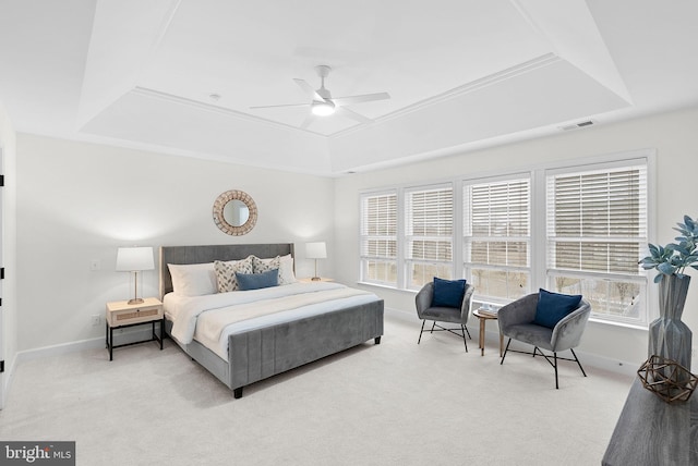 carpeted bedroom featuring ceiling fan, a raised ceiling, visible vents, and baseboards