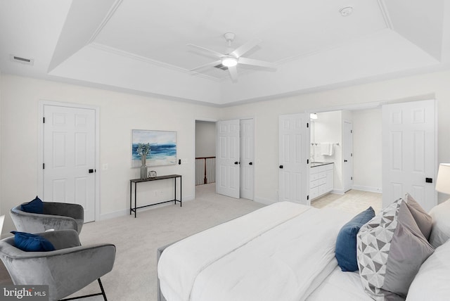 bedroom with light carpet, visible vents, a tray ceiling, and baseboards