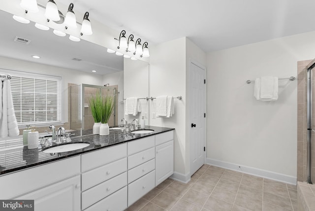 full bath featuring visible vents, a sink, a shower stall, and tile patterned floors