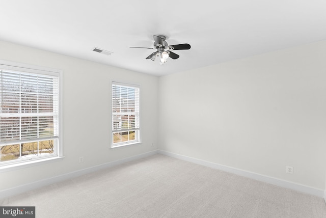 empty room with baseboards, a wealth of natural light, and light colored carpet