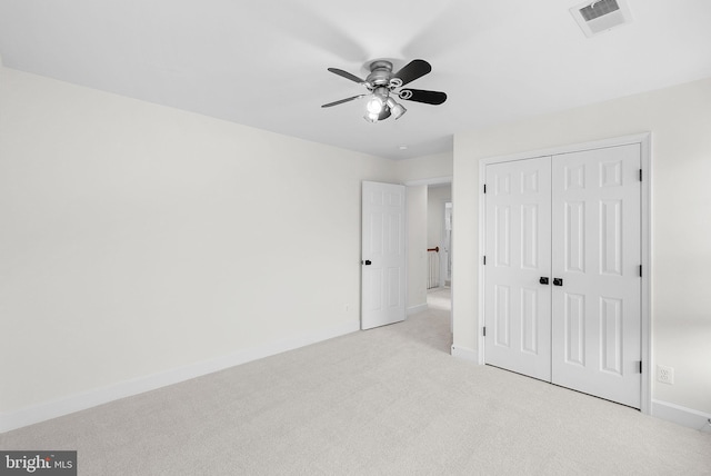 unfurnished bedroom featuring carpet, a closet, visible vents, ceiling fan, and baseboards