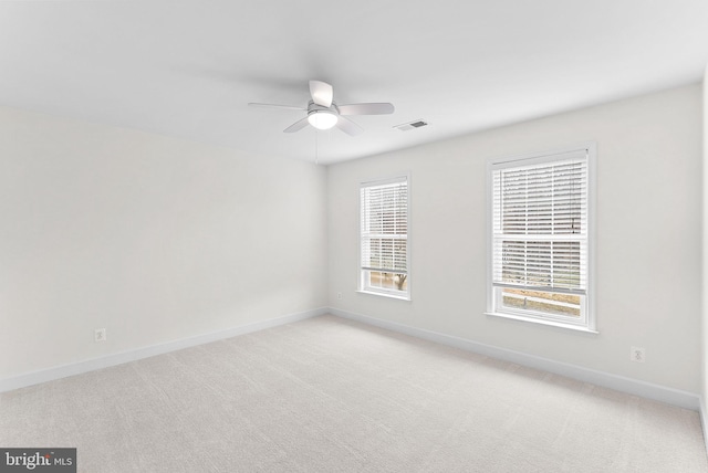 unfurnished room featuring visible vents, baseboards, ceiling fan, and light colored carpet