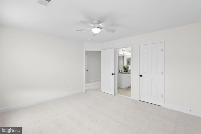 unfurnished bedroom with ceiling fan, ensuite bathroom, light colored carpet, visible vents, and baseboards