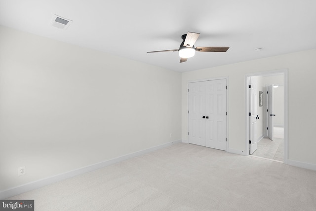 unfurnished bedroom with light carpet, visible vents, baseboards, a ceiling fan, and a closet