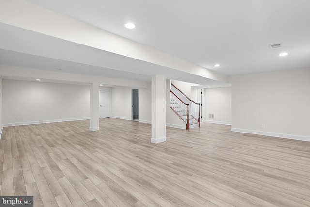 finished basement with light wood finished floors, baseboards, visible vents, stairway, and recessed lighting