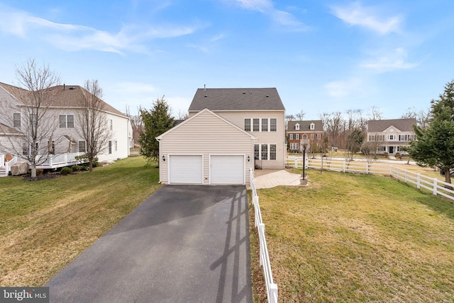 view of front of home featuring a garage, aphalt driveway, a front yard, and fence