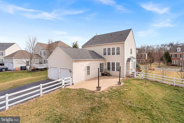 back of house featuring a lawn, an attached garage, a patio area, fence, and a residential view