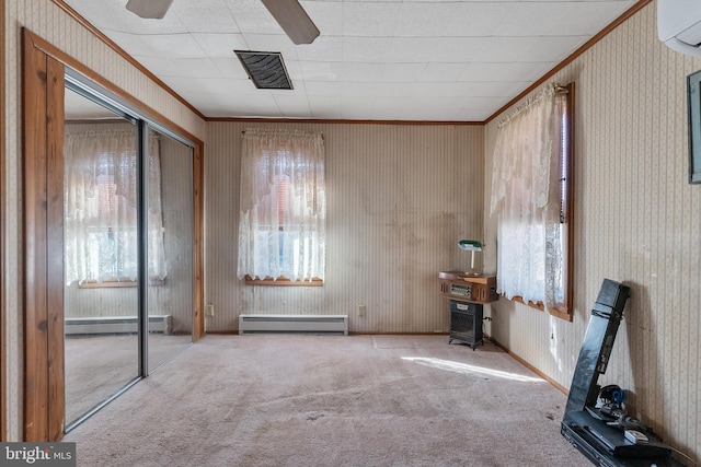 carpeted empty room with baseboard heating, a baseboard heating unit, ornamental molding, a wall mounted air conditioner, and wallpapered walls