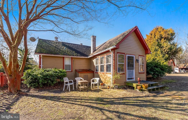 view of front of house featuring a chimney and a front lawn