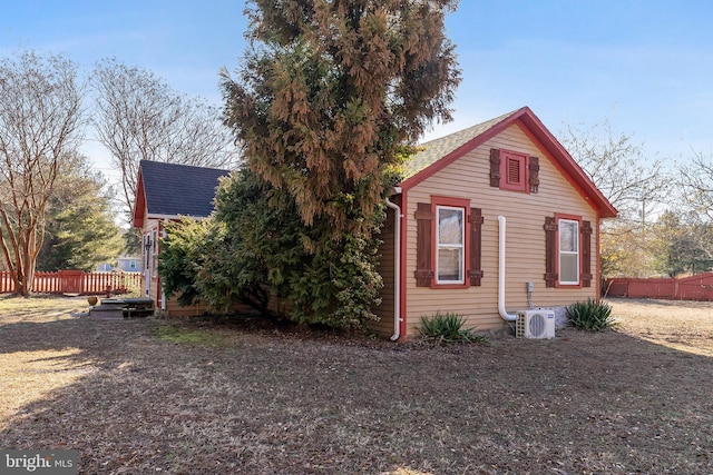 view of home's exterior featuring a shingled roof, ac unit, and fence